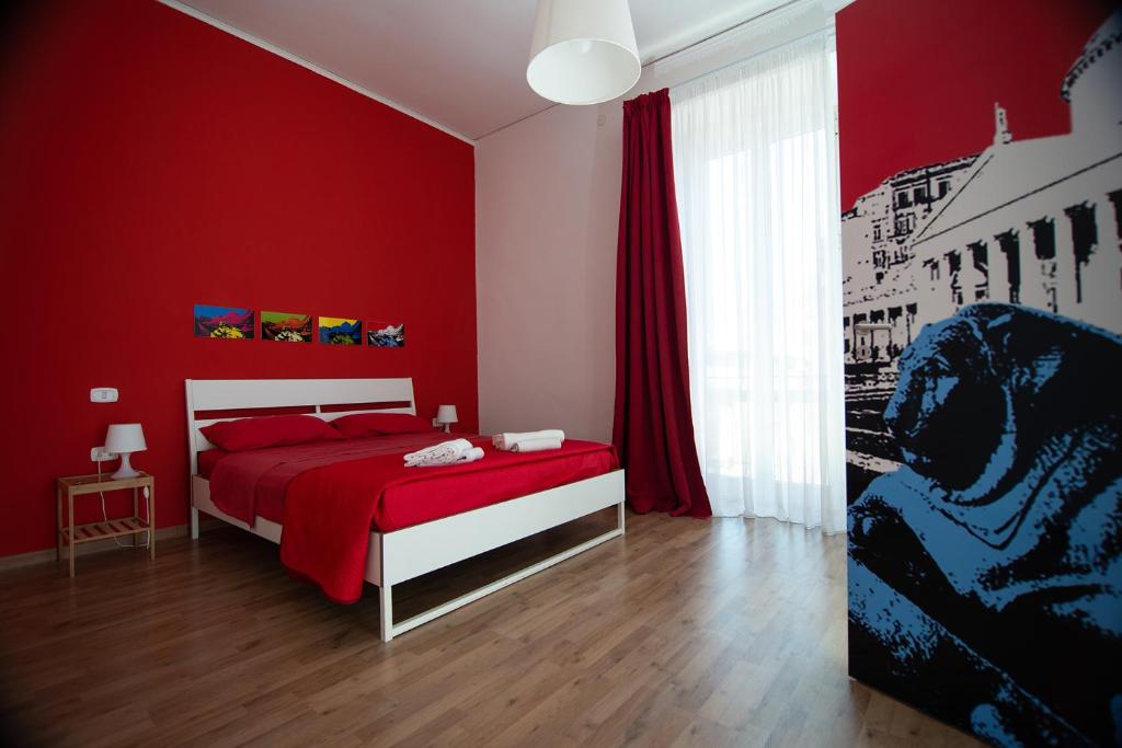ナポリにあるB&B Tarumbòの赤い壁のベッドルーム(ベッド1台付)