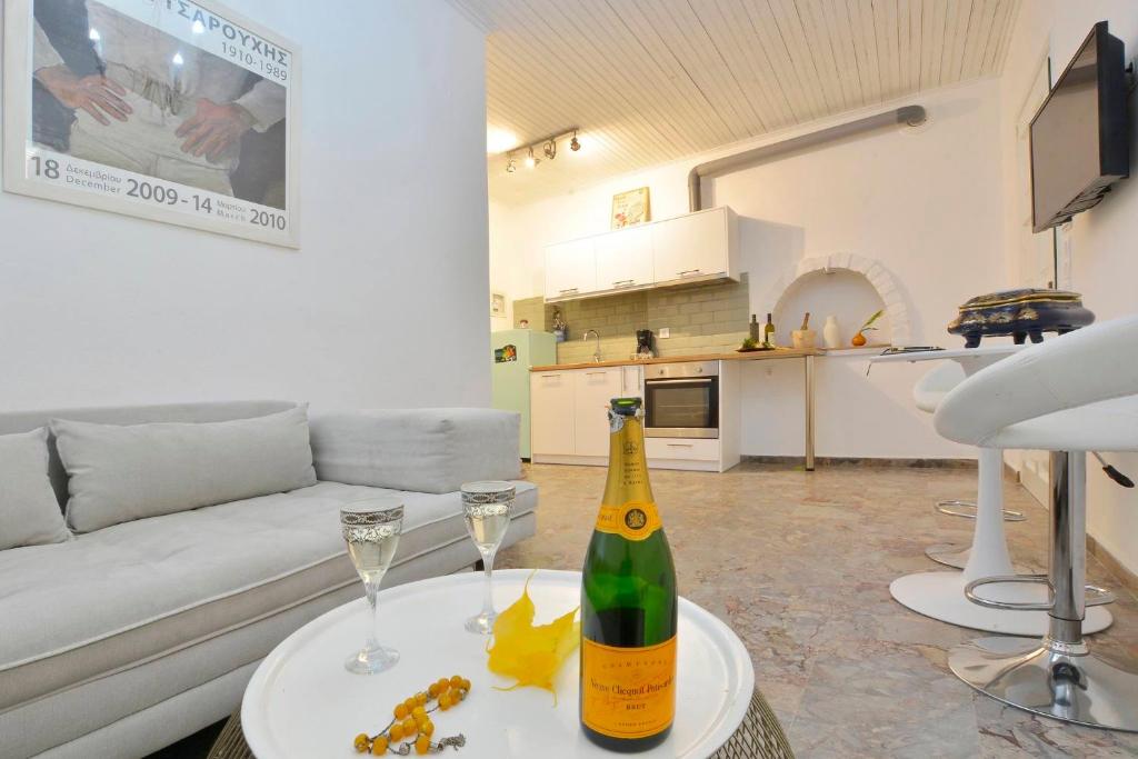 eine Flasche Champagner und zwei Gläser auf dem Tisch im Wohnzimmer in der Unterkunft Jerry Afro in Kanálion
