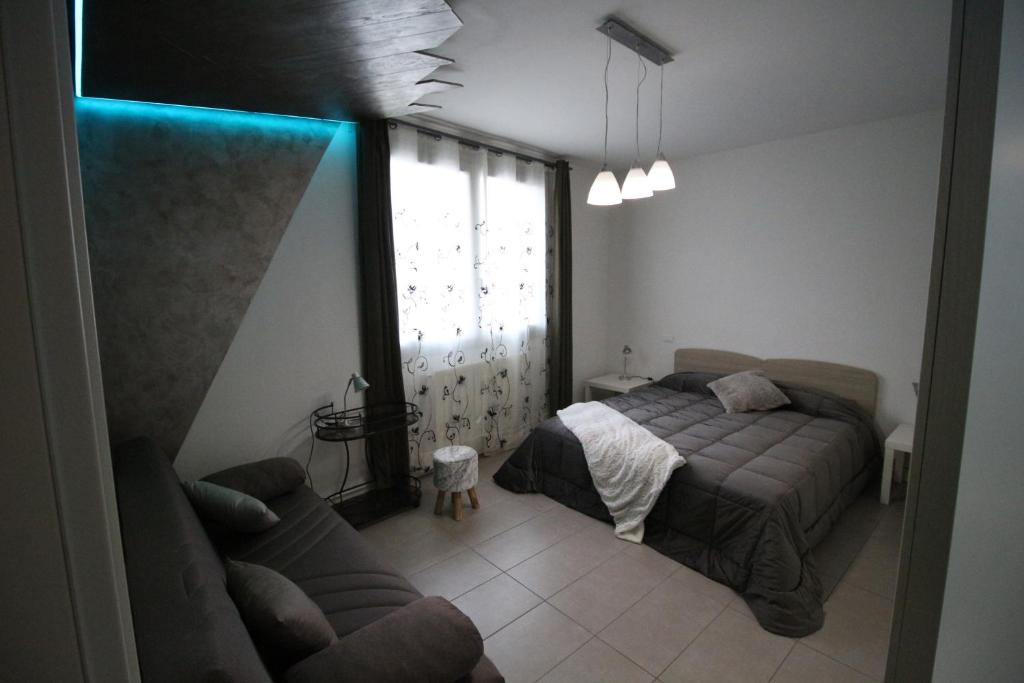 sypialnia z łóżkiem, kanapą i oknem w obiekcie casa David w Sienie