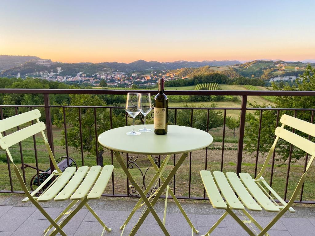 a table with a bottle of wine and two chairs at Vista sul Forte in Gavi