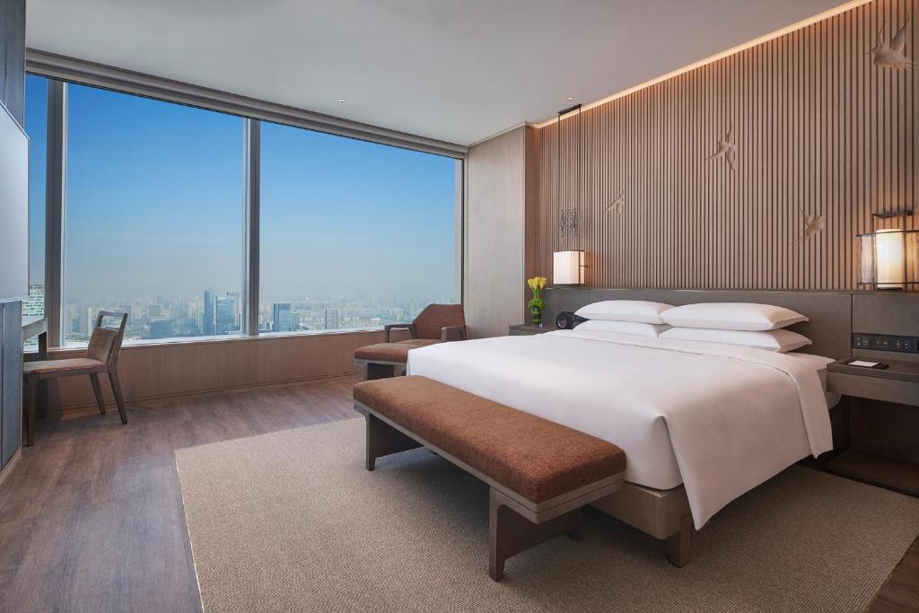 Un dormitorio con una cama grande y grandes ventanales. en Grand Hyatt Hefei, en Hefei