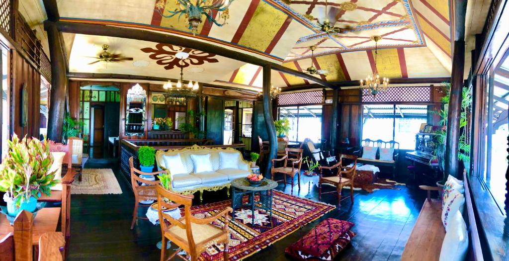salon z kanapą, stołami i krzesłami w obiekcie Posada La Patriciana w mieście Taal