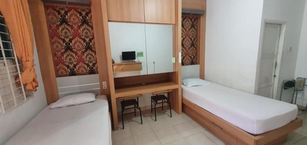 Postel nebo postele na pokoji v ubytování Rumah Dempo Syariah