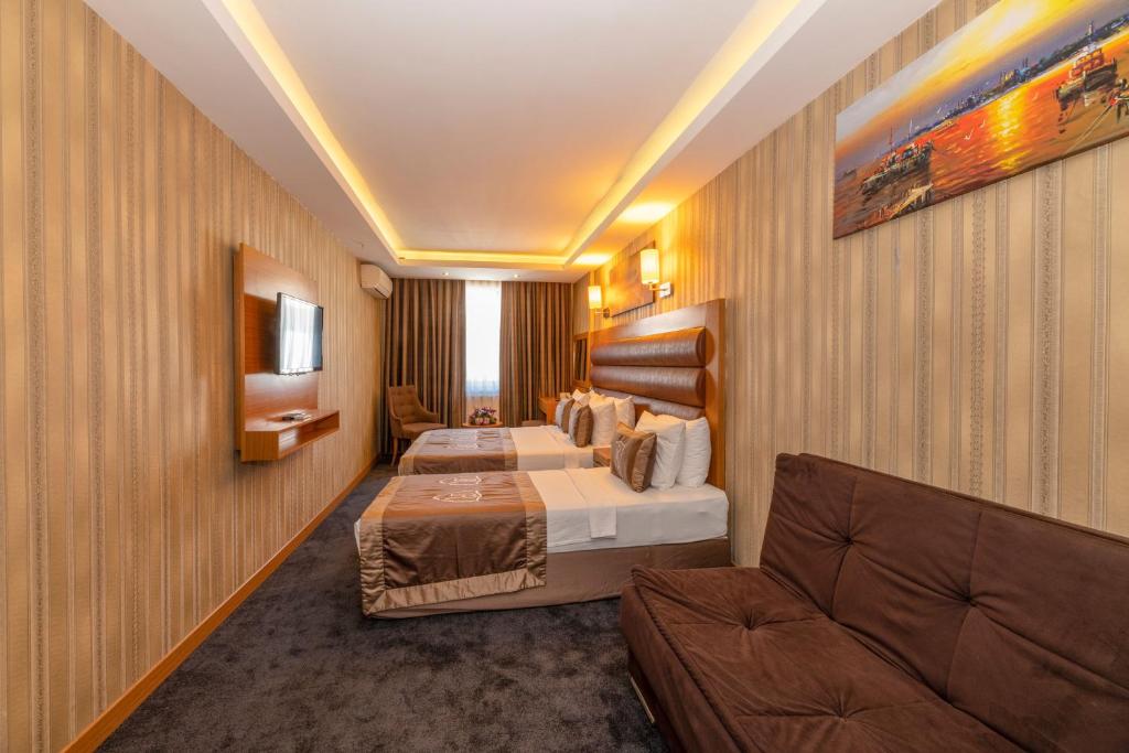 a hotel room with two beds and a couch at Regno Hotel in Istanbul