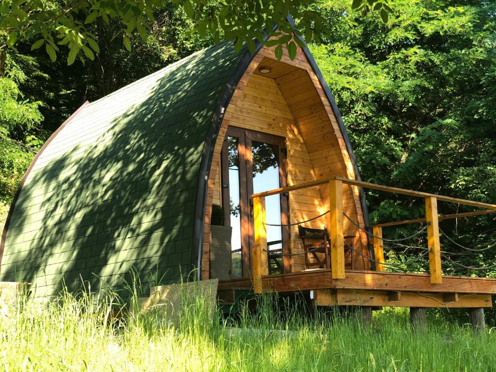 een klein houten koepelhuis in het gras bij Glamping Jezero in Čačak