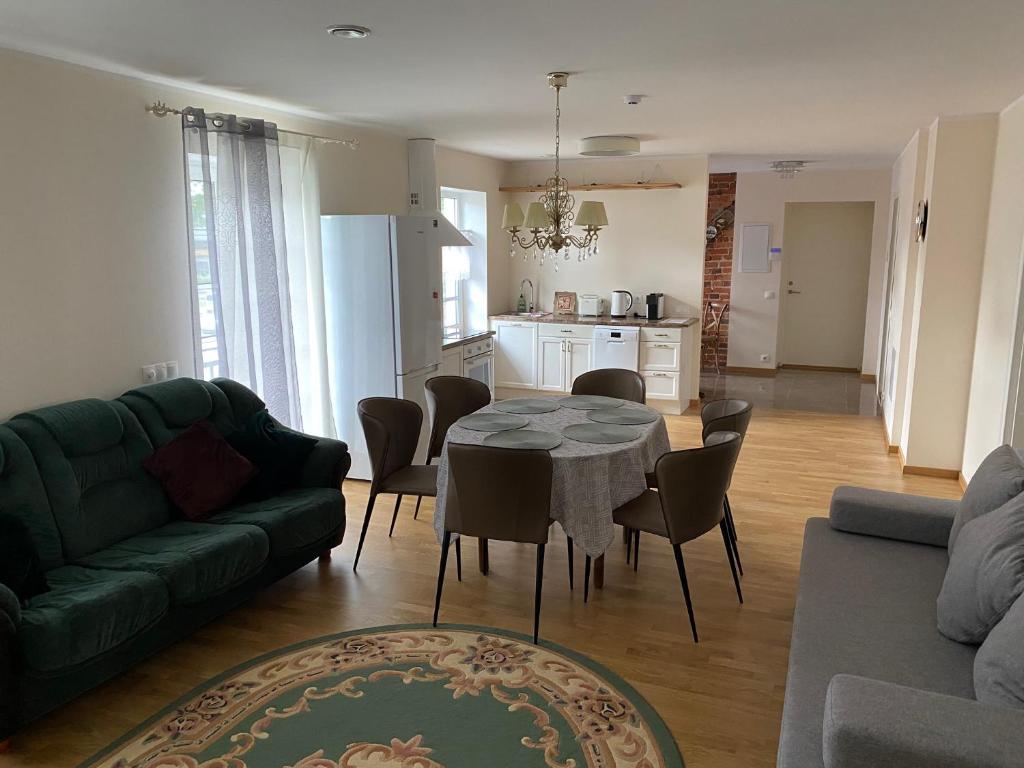 a living room with a table and a green couch at Ontic Wellness Apartments in Tartu