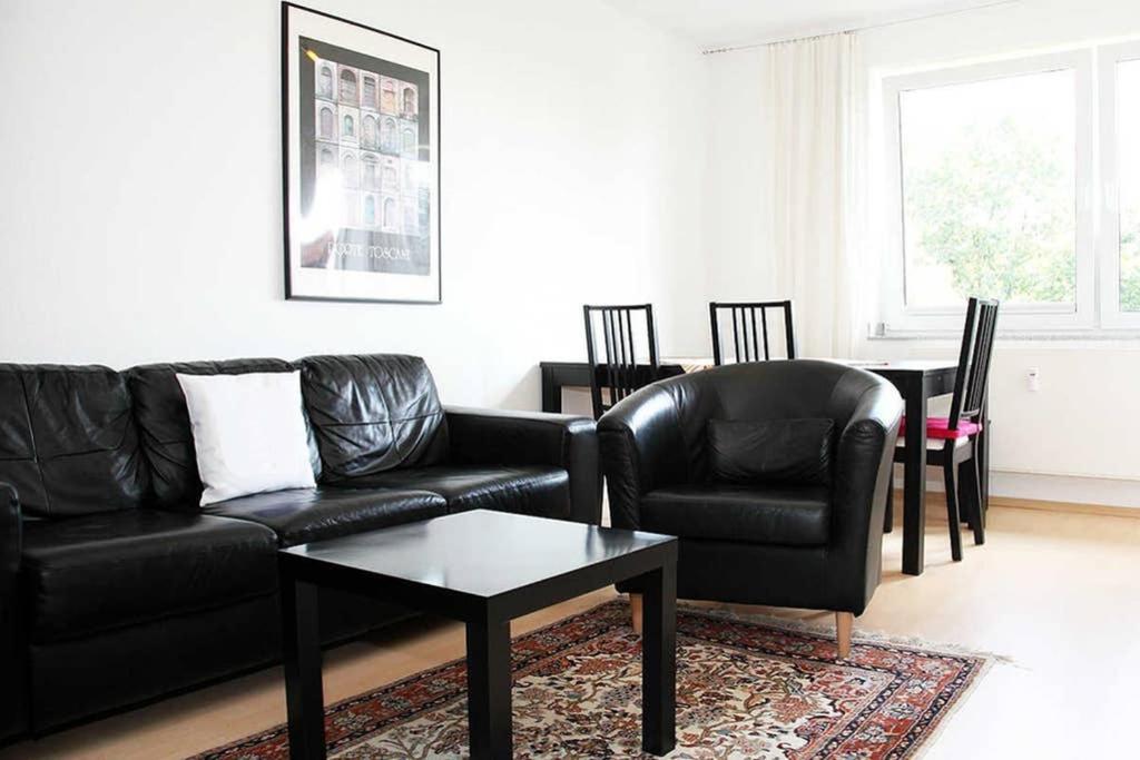 uma sala de estar com um sofá e duas cadeiras e uma mesa em City Apartments Cologne - Apartment 2 em Colónia