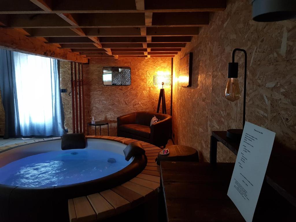 a bathroom with a large tub in a room at Odyssée - Chambre d'hôtes avec spa et sauna privés in Zeggers-Cappel