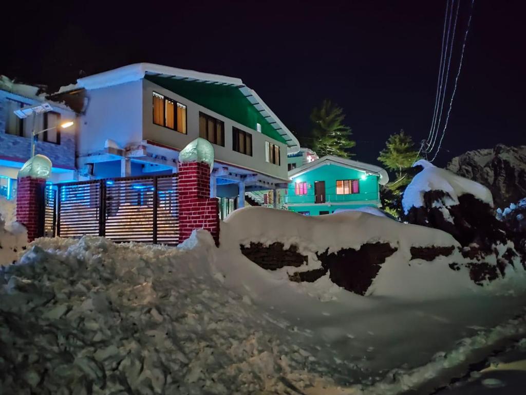 una casa con nieve delante de ella por la noche en Mountain view stay in Auli en Joshīmath