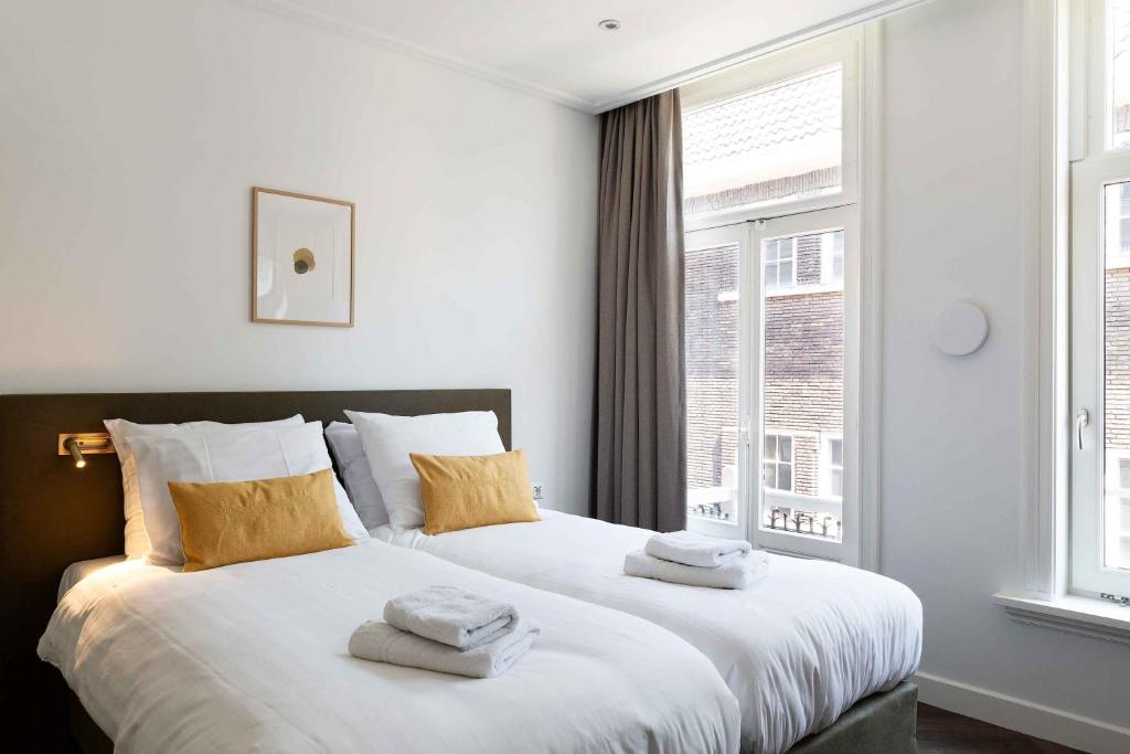 een slaapkamer met een groot bed en handdoeken bij Anegang Boutique Hotel in Haarlem
