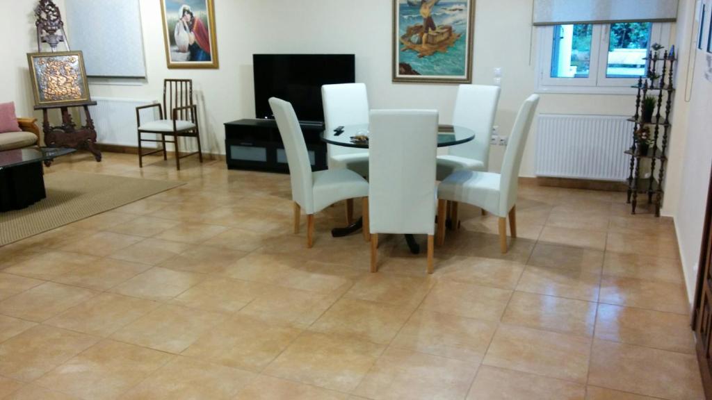 jadalnia ze stołem i białymi krzesłami w obiekcie Lovely 2-Bedroom Apartment At Greek Riviera w mieście Vari