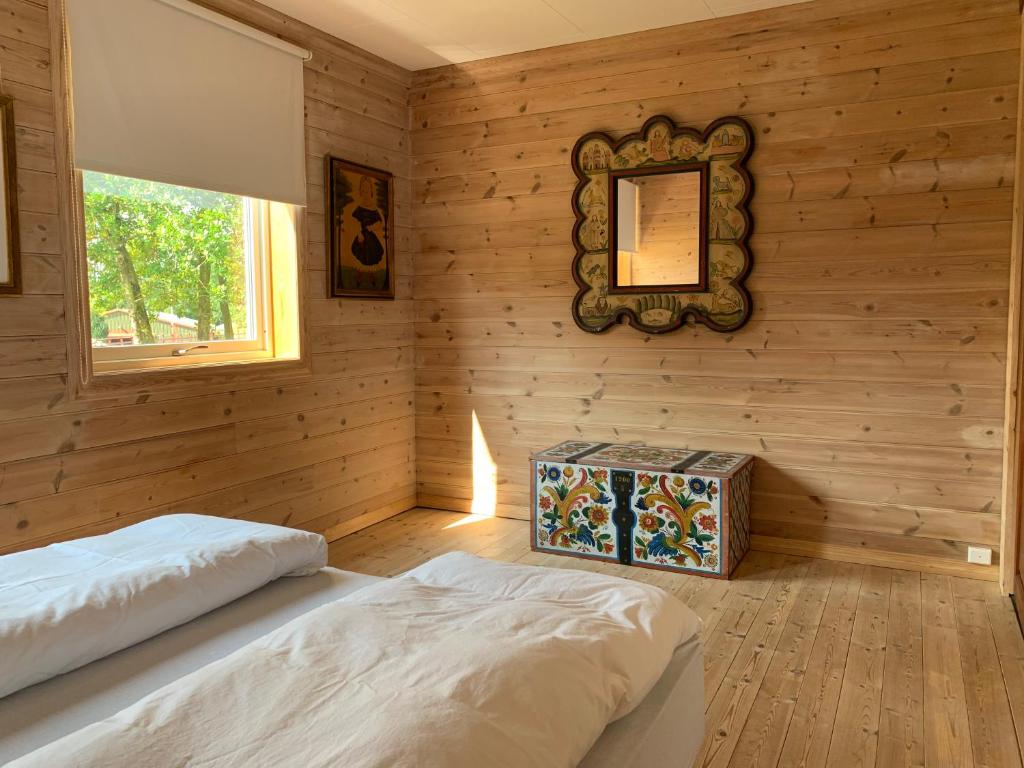 a bedroom with wooden walls and a bed and a mirror at Moldegaard Farmhouse - Apartment A in Moldegard