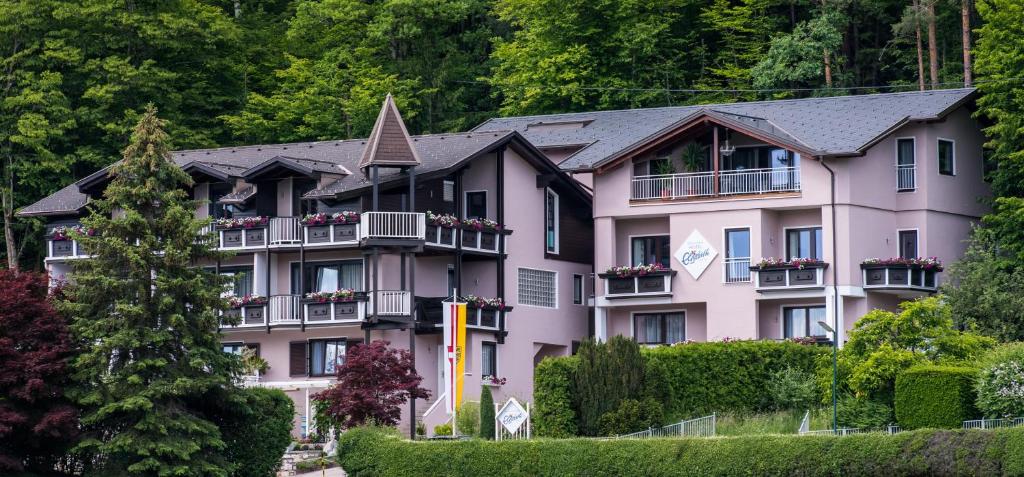 a large pink building with flowers on the balconies at Hotel Garni ELISABETH in Pörtschach am Wörthersee