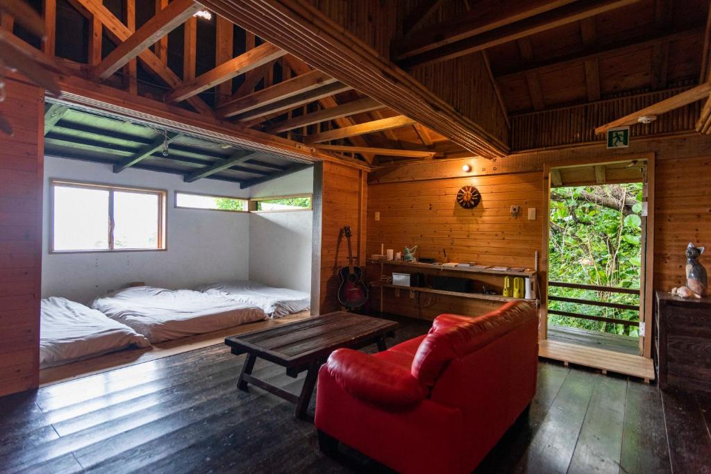 um quarto com uma cama, um sofá e uma mesa em Villa SACHIIBARU em Nanjo