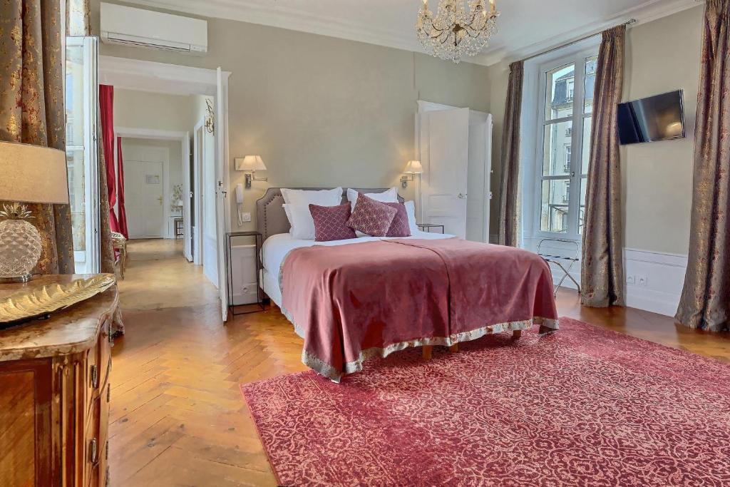 a bedroom with a large bed with a red blanket at Le Tardif, Noble Guesthouse in Bayeux