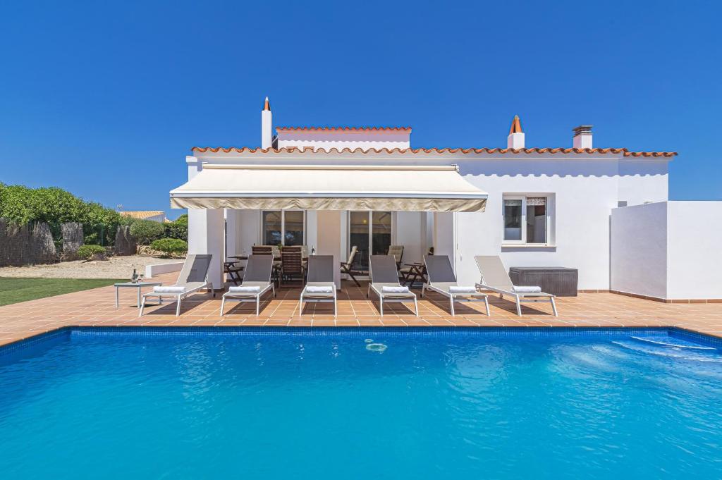 a villa with a swimming pool in front of a house at Villa Astur in Binibeca