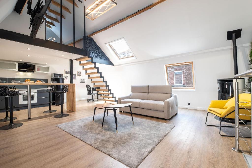 a living room with a staircase and a couch at Magnifique Loft , Proche Métro Lille in Croix