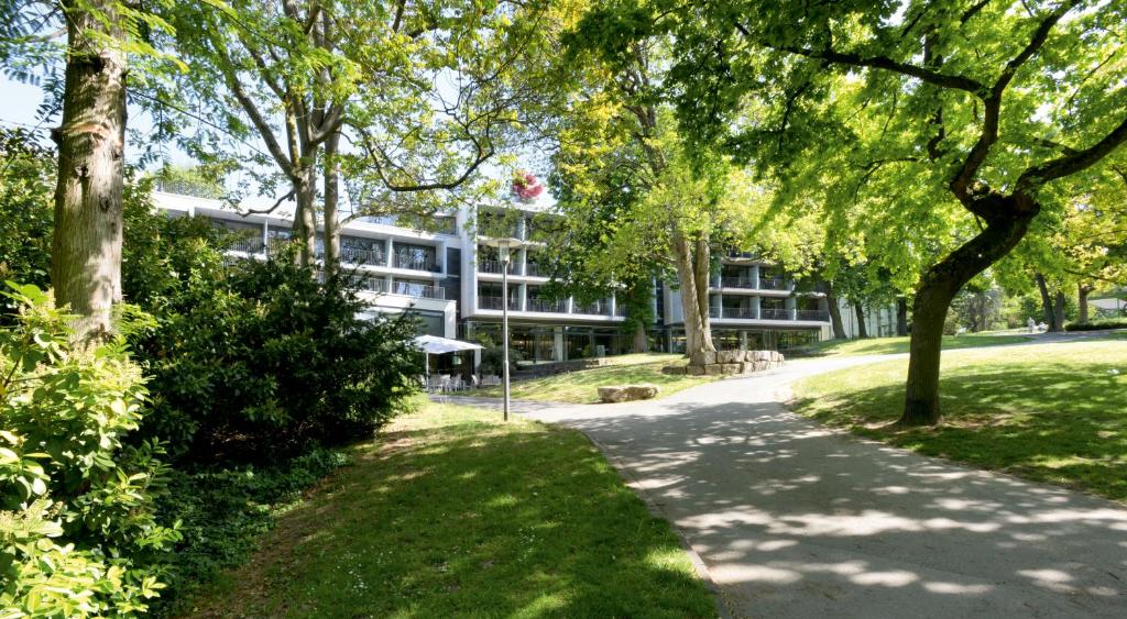 ein Gebäude inmitten eines Parks mit Bäumen in der Unterkunft FAVORITE Parkhotel in Mainz