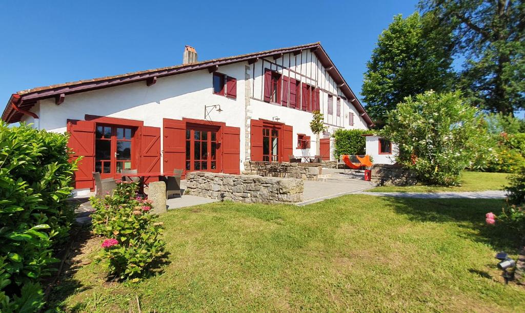 a house with red doors and a yard at La ferme d'Ika in Saint-Jean-de-Luz
