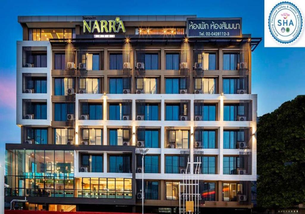a large building with a sign on top of it at Narra Hotel in Bangkok
