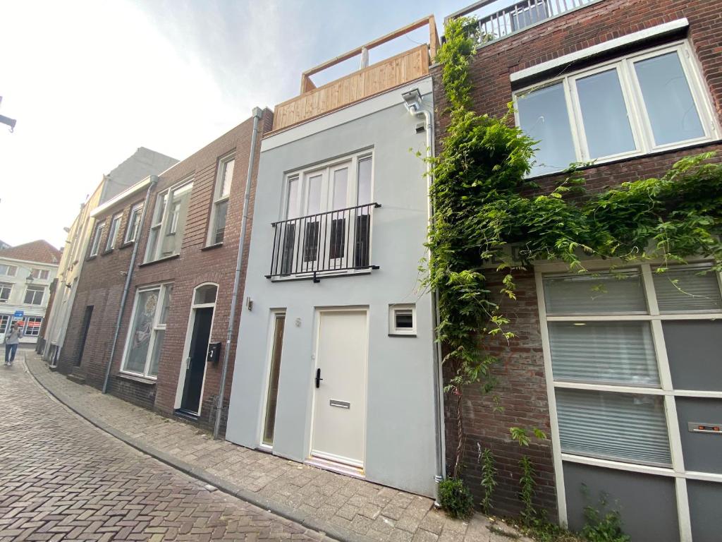 a brick building with a white door on a street at Stylish house in the heart of Breda city center in Breda