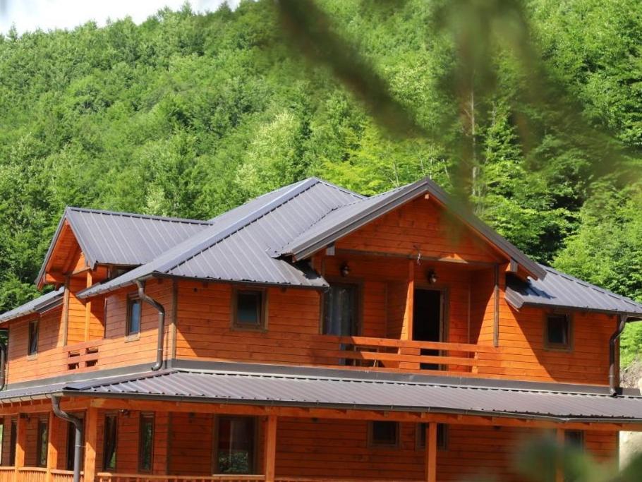 a large wooden house with a metal roof at Bujtina Malaj in Valbonë