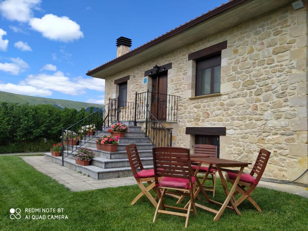 a table and chairs in front of a stone house at Chalet en Las Merindades, Nofuentes in Nofuentes