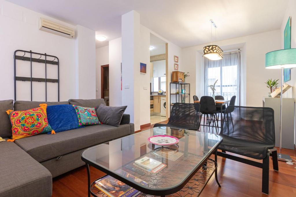 a living room with a couch and a glass table at Apartamento Madroño Regina in Seville