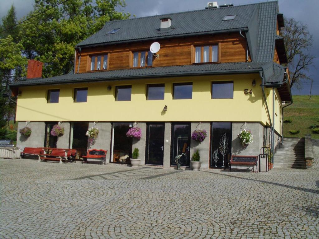 ein großes gelbes Gebäude mit schwarzem Dach in der Unterkunft Wincentówka - Realizujemy Bon Turystyczny in Czarna