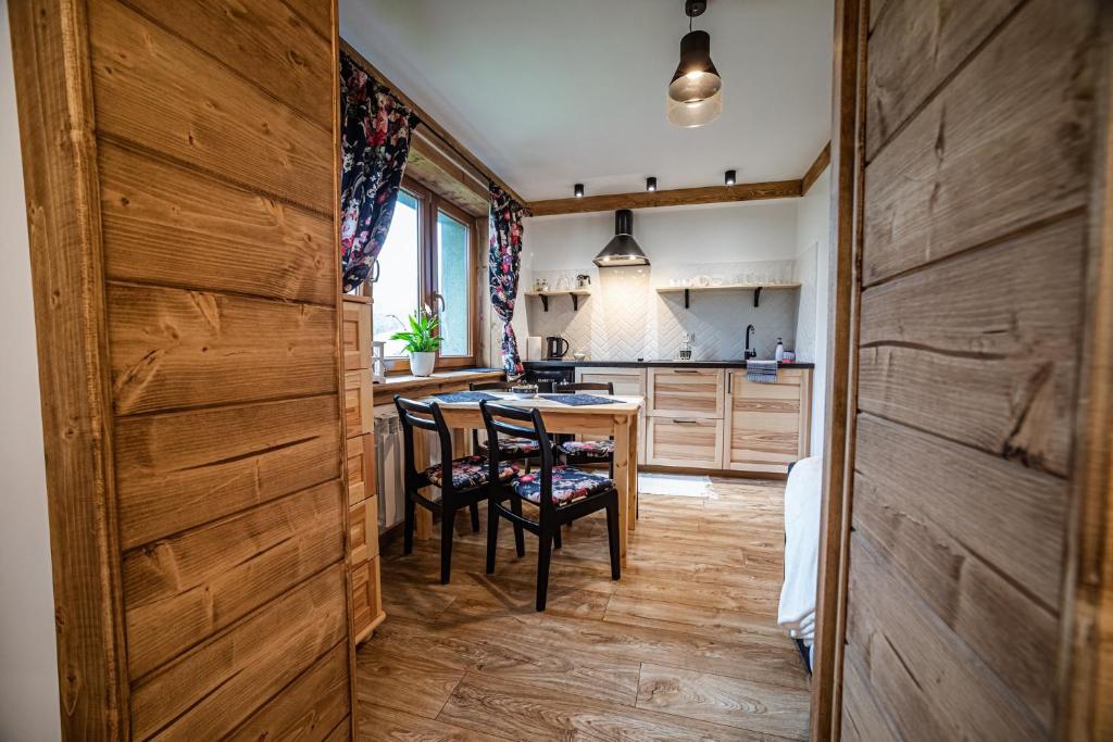 a kitchen with wooden walls and a table and chairs at Apartament Stary Mlyn in Zakopane