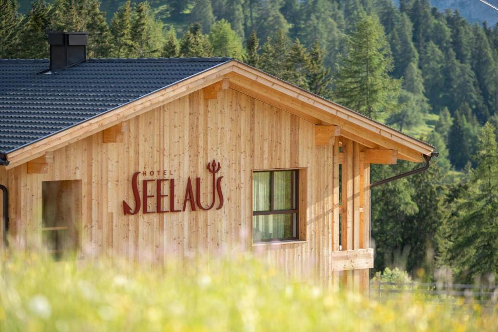 een houten gebouw met de woorden 'seaks' erop geschreven bij Hotel Seelaus in Alpe di Siusi