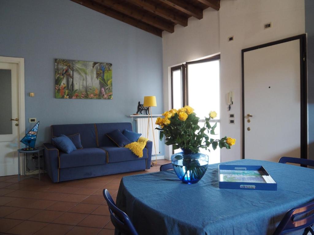 salon ze stołem z wazonem kwiatów w obiekcie Casa Mariposa w mieście Desenzano del Garda