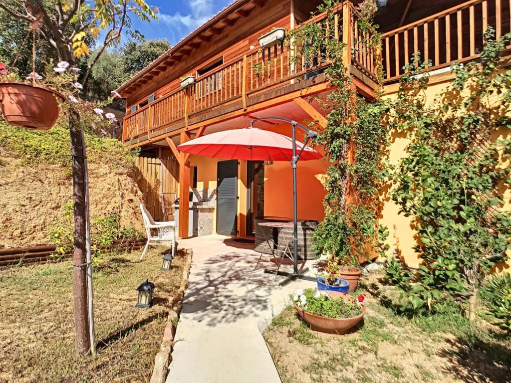 a patio with an umbrella and a house at Alegria in Arbellara