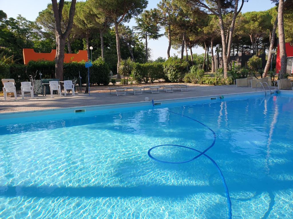 a swimming pool with a hose in the water at Villaggio Mithos in Misano Adriatico