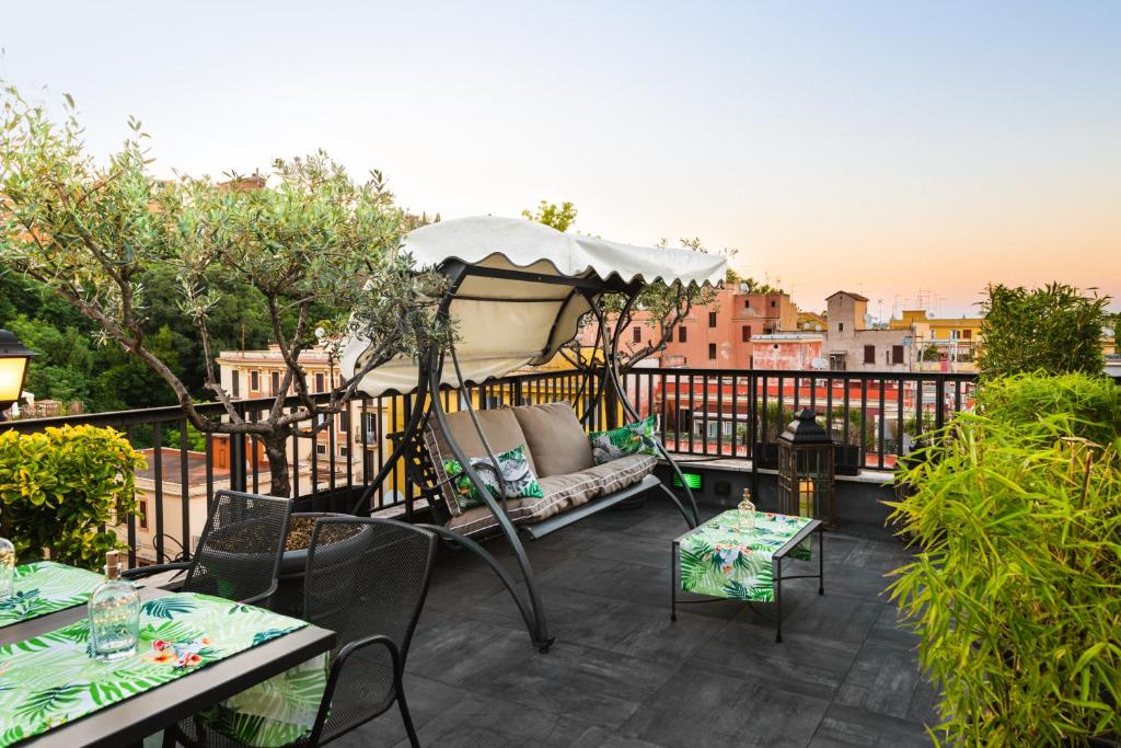 a patio with a couch and an umbrella on a balcony at Trilussa Palace Hotel Congress & Spa in Rome