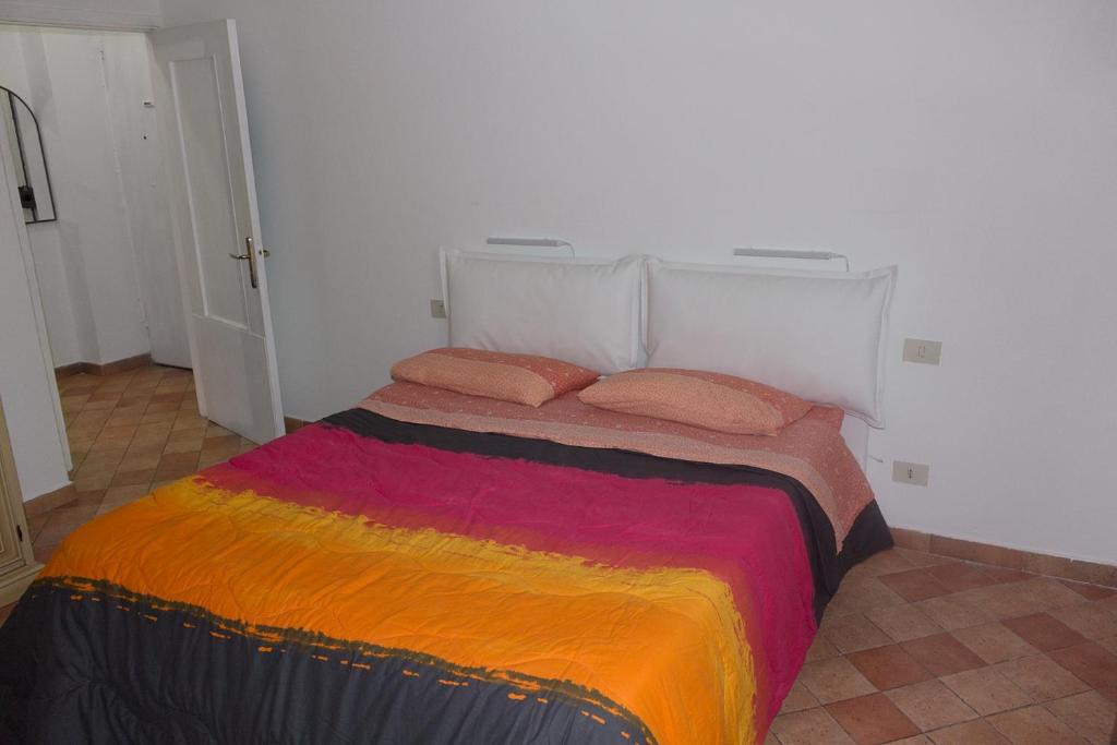 ein Bett mit einer bunten Decke auf einem Zimmer in der Unterkunft Da Vici in La Spezia