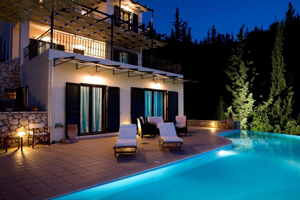 a villa with a swimming pool at night at VILLA TIMOKLIA in Tsoukalades