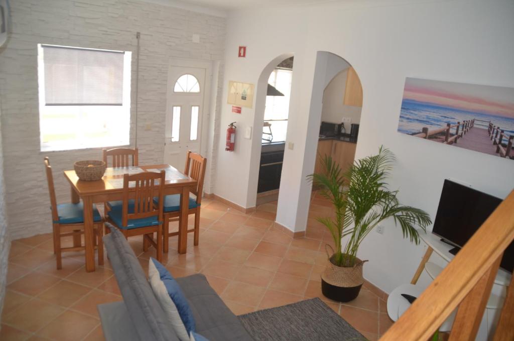 比什普鎮的住宿－Casa Flora T1 - Vila do Bispo，用餐室以及带桌椅的起居室。