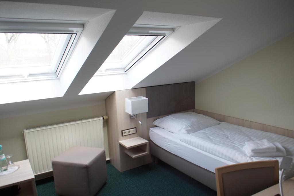a bedroom with a bed and two skylights at Hotel & Gasthaus Zum Eichenkranz in Luckenwalde