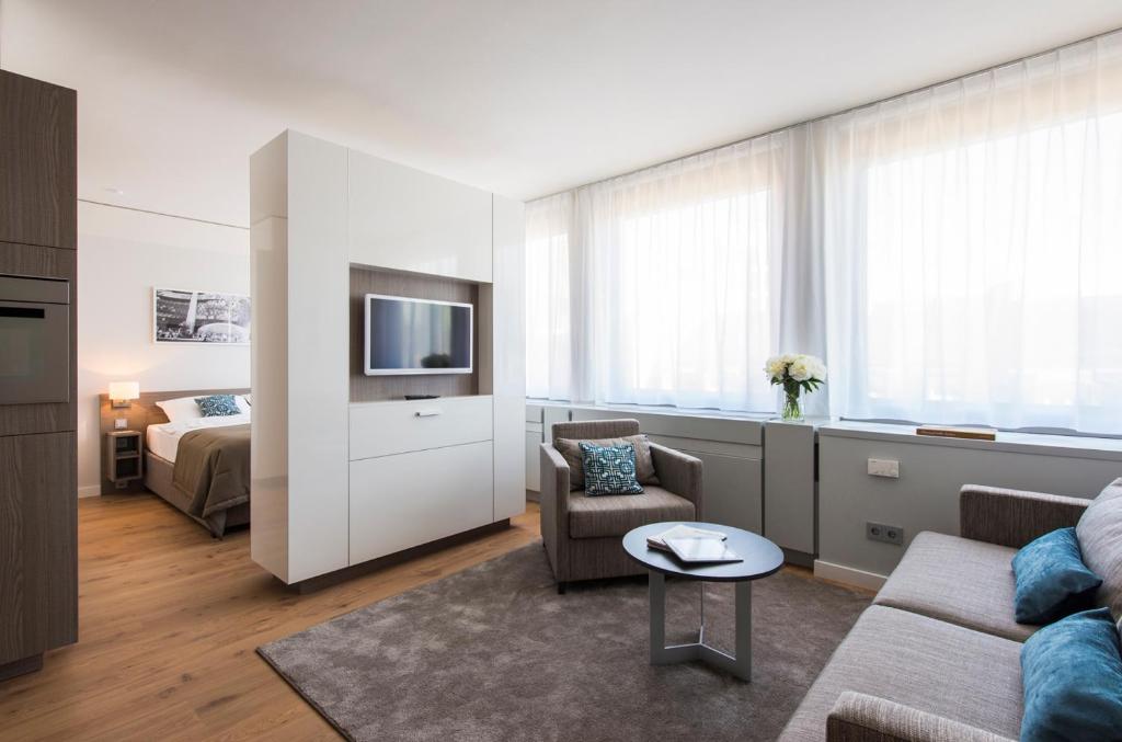 a living room with a couch and a tv at Brera Serviced Apartments Frankfurt Oper in Frankfurt