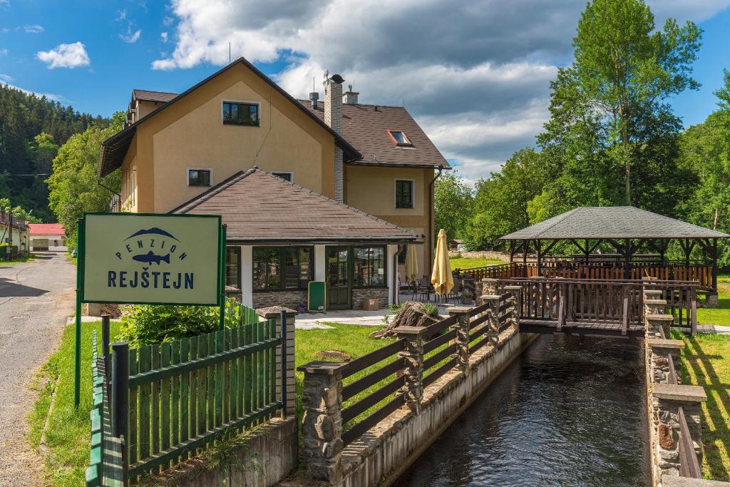 a restaurant with a sign in front of a river at Penzion Rejštejn in RejÅ¡tejn