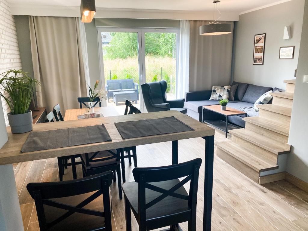 Il comprend une cuisine et un salon avec une table et des chaises. dans l'établissement Domki letniskowe Aqua, à Mielno