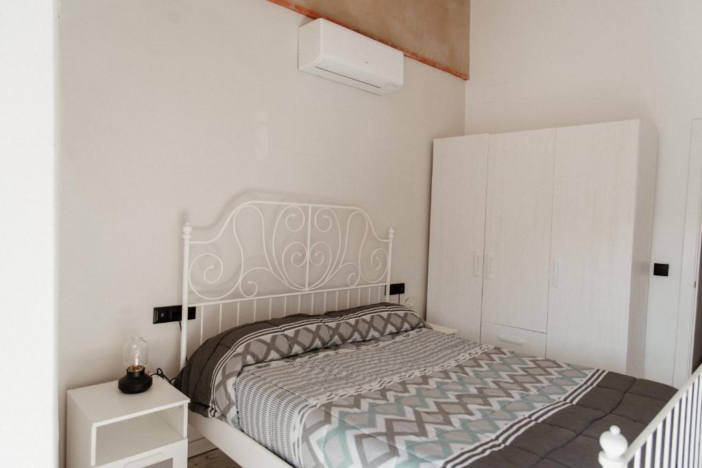 a white bedroom with a bed and a white cabinet at Casa Rural Turgalium in Trujillo