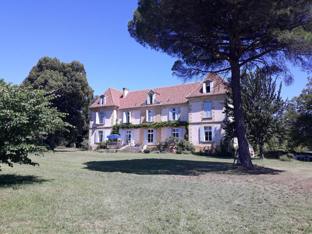 een groot huis met een boom in de tuin bij Château Le Tour - Chambres d'Hôtes in Faux