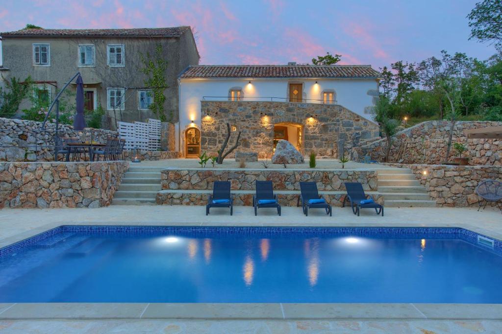a house with a swimming pool in front of a house at Villa MAY in Gostinjac