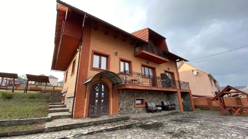 une maison avec un balcon sur le côté de celle-ci dans l'établissement Guest house Mountain View, à Polyana