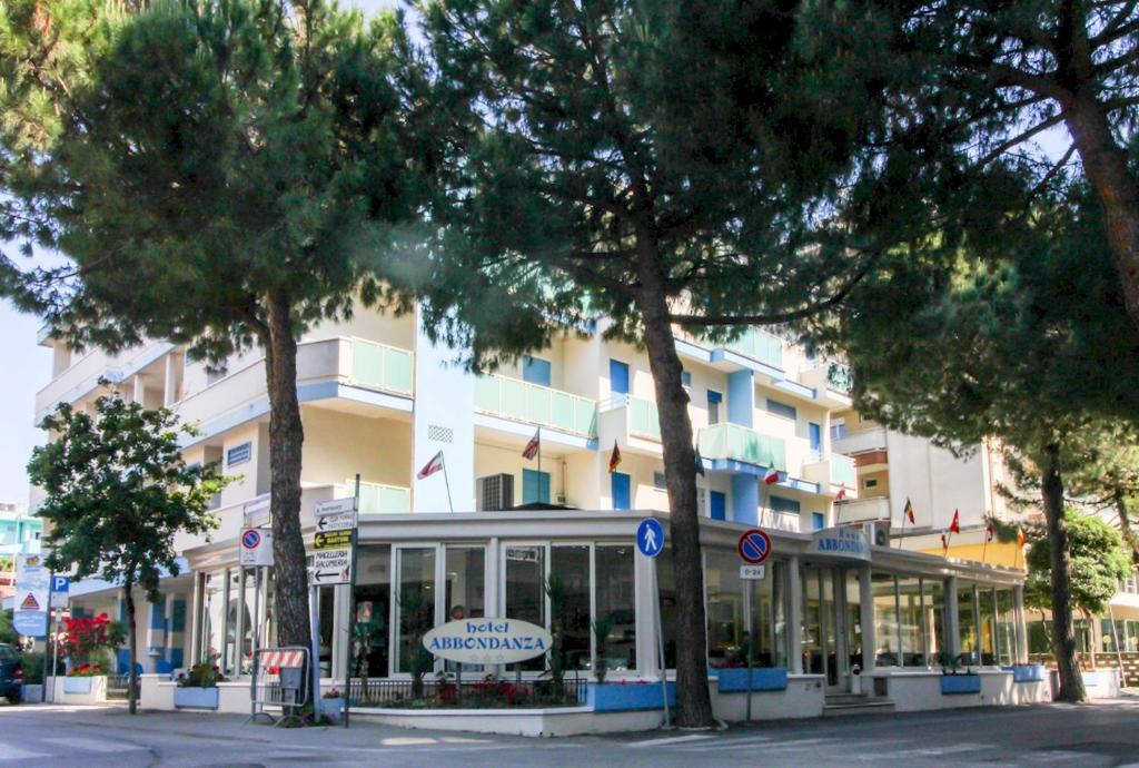 un gran edificio blanco con árboles delante de él en Hotel Abbondanza, en Gatteo a Mare