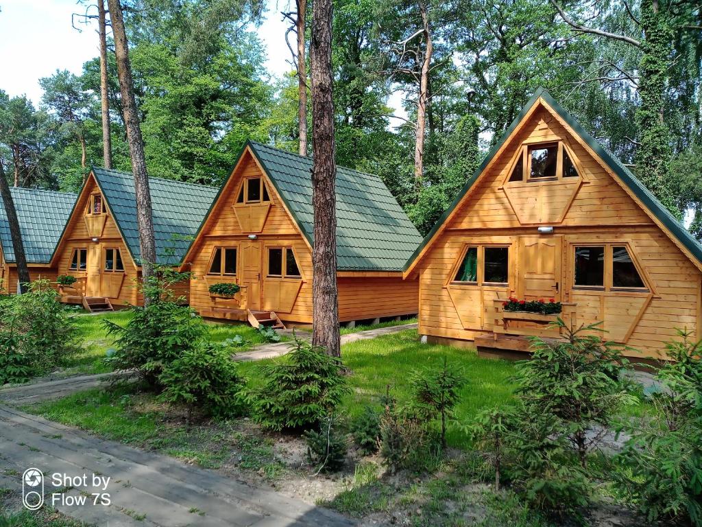 un par de casas de troncos en el bosque en Sławska Poręba en Sława