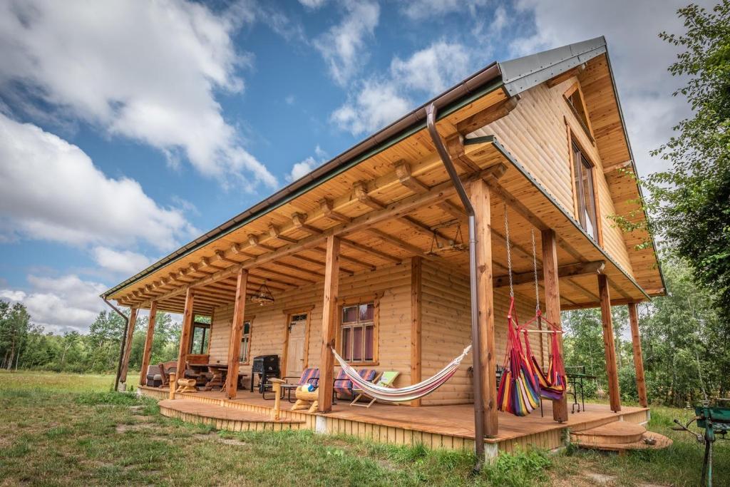domek z bali z hamakami na polu w obiekcie Siedlisko Matiaszówka w mieście Matiaszówka