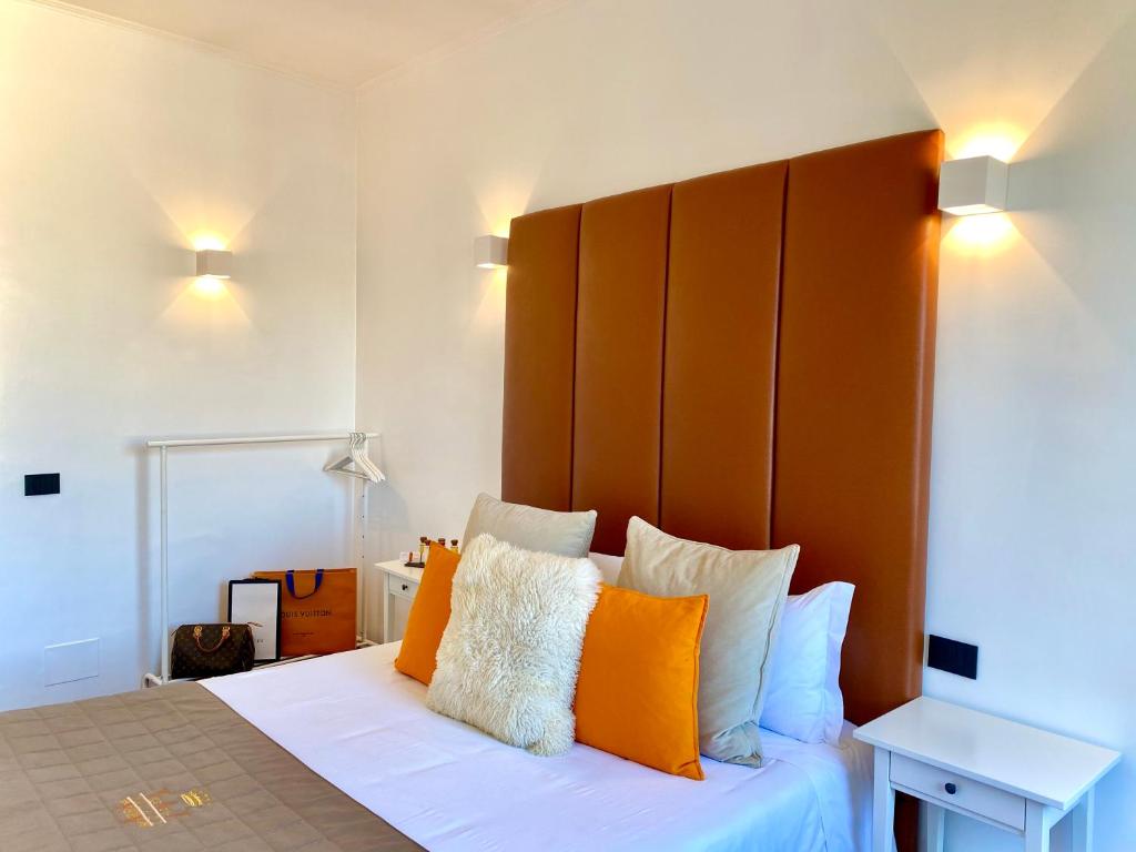 a bedroom with a large bed with orange and white pillows at Palace fontana di trevi home in Rome